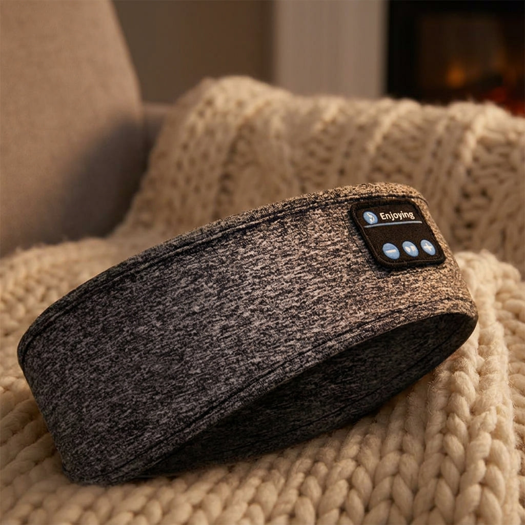 Grey marl sleep headband laid on a chunky knit blanket, showing the thicker fabric of the Bluetooth 5.2 version